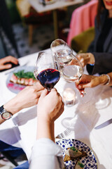 several people drink white wine from glasses