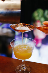 the bartender makes a cocktail with an orange