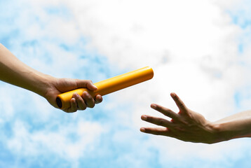 Close up hand set baton from hand to hand on sky background. Business concept for teamwork and team builder. - obrazy, fototapety, plakaty