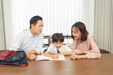 Portrait of happy smiling Asian Family. A student studying homework from school at home or house in family relationship. Love of father, mother, and son. People lifestyle. Education activity.