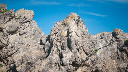 Rocas graniticas con manchas de liquen amarillo en el litoral bajo cielo azul