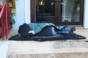 Homeless man sleeping on steps in shelter in New York City