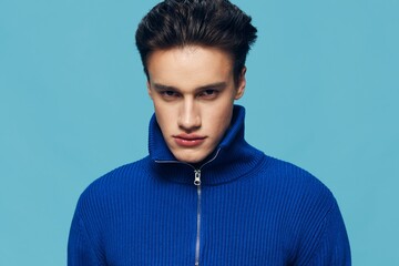 horizontal close-up portrait of an angry, aggressive man standing on a light blue background looking into the camera