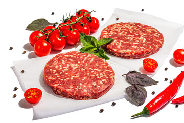 Raw steak cutlets from minced beef meat isolated on white background. Fresh vegetables, basil