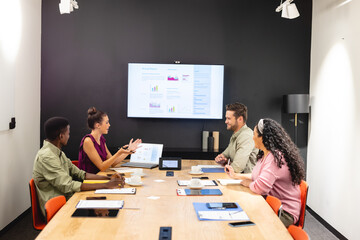 Multiracial businessmen and businesswomen discussing during meeting in board room
