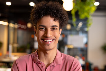 Portrait of smiling biracial young businessman in creative office