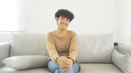 Portrait of happy smiling young Asian business woman girl person sitting on sofa isolated at home or house. People lifestyle.