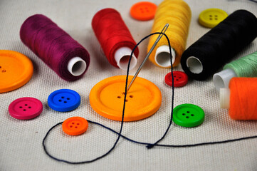 Sewing thread spools and multicolored buttons.