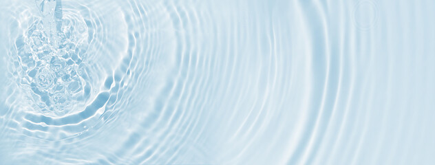 close-up of a rippled water surface from above, sunshine on water jet and flowing waves and...