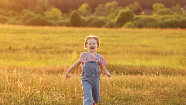 A happy child with a toy plane runs through a green meadow in the park