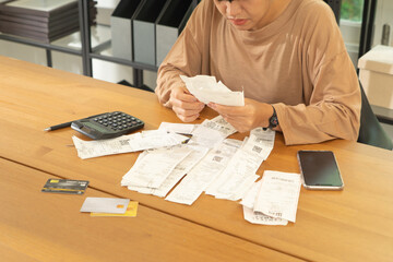 Portrait of stressed Asian woman, audit person and confused by calculate expense from invoice or receipt bills debt. No money to pay, mortgage or loan,bankruptcy at home.People lifestyle