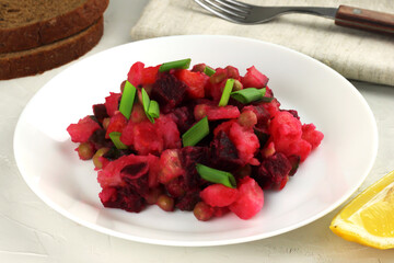Vinaigrette. Traditional russian salad with boiled vegetables in a white plate on grey background. Selective focus
