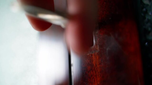 Angle close-up of an old vintage key turning in the keyhole in an old wooden sideboard