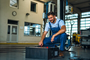 Obraz na płótnie Canvas Portrait Shot of a Handsome Mechanic Working on a truck workshop Service. Professional Repairman. Modern Clean Workshop.
