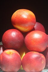 Fototapeta na wymiar Peaches and nectarines are the same species, though they are regarded commercially as different fruits. The skin of nectarines lacks the fuzz (fruit-skin trichomes) that peach skin has