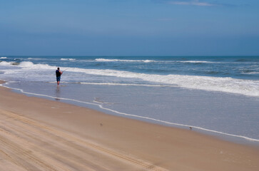 Man fishing in the open sea on the Outer Banks in North Carolina, USA.