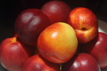 Peaches and nectarines are the same species, though they are regarded commercially as different fruits. The skin of nectarines lacks the fuzz (fruit-skin trichomes) that peach skin has