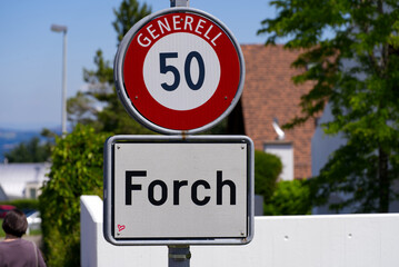 Scenic landscape with traffic sign at Forch Küsnacht with mountain panorama in the background on a sunny summer day. Photo taken June 12th, 2022, Forch Küsnacht, Switzerland.