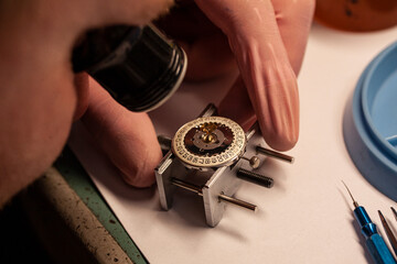 Watch repair at watchmaker wiyh magnifying glass. Focus on date disc inside case. Maintenance of...