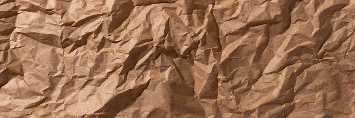 Brown crumpled, wrinkled recycle craft paper texture background banner. Wide panoramic header