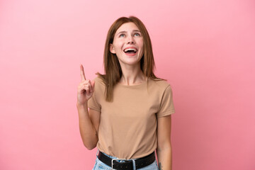 Young English woman isolated on pink background pointing up and surprised