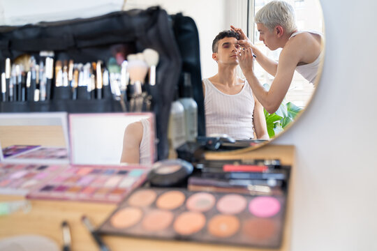 Transgender Man Applying Eyeshadow To His Boyfriend