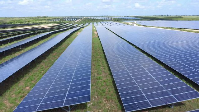 Drone Low Angle Perspective Infinity Shot Moving Backwards Overhead Solar Panel Rows at El Soco Photovoltaic Park in Dominican Republic