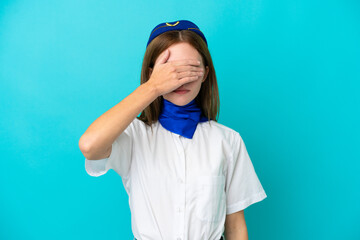 Airplane stewardess English woman isolated on blue background covering eyes by hands. Do not want to see something