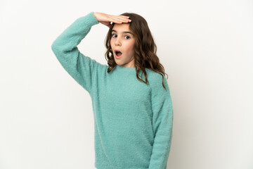 Little caucasian girl isolated on white background doing surprise gesture while looking to the side