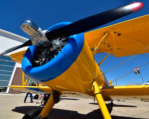 A wide angle view of a colorful biplane at an airshow. © Don Masten II