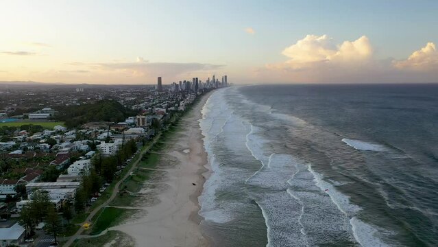 Gold Coast Australia. Drone clip moving backwards parallel with the beach with the city in the distance. People on the beach and in the surf