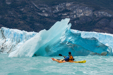 kayaking between an iceberg in the mountains