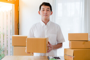 person with boxes , Portrait of Asian man packing box and check list in the office business , SME internet work from home business .