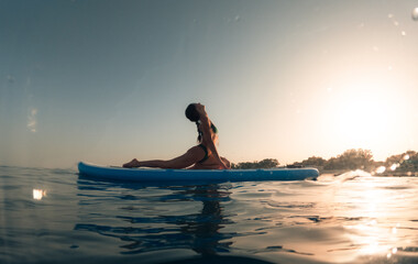 Fototapeta na wymiar Stretching exercises on a paddle sup board