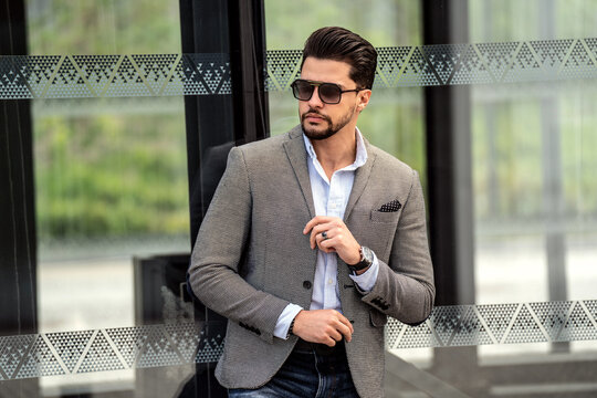 Handsome businessman posing outside business centre. Portrait of a confident young bearded male model