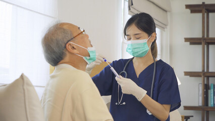 Happy woman nurse, daughter taking a covid test to sick old senior elderly patient lying on bed in bedroom in home in medical. Coronavirus. Asian Thai people lifestyle. Family