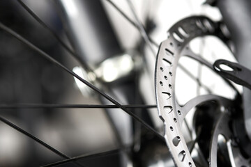 Bicycle disk brakes close up, metal disc attached to bike wheel, effective mountain bicycle brakes