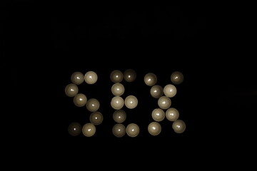 word sex written with burning candles isolated on black background