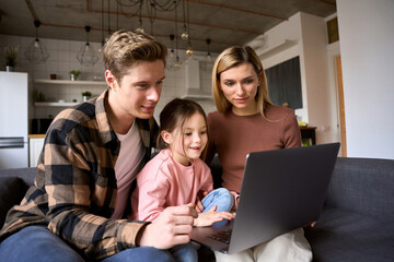 Happy family young parents and kid child daughter using laptop computer having fun learning online...