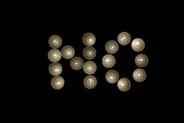 word no written with burning candles isolated on black background