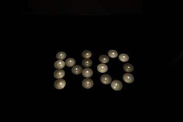word no written with burning candles isolated on black background