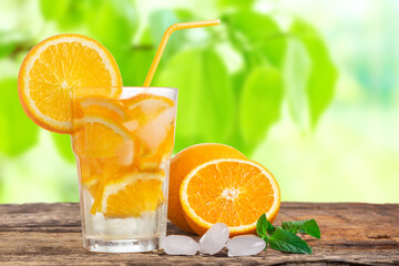 Natural lemonade with mint and fresh oranges on wooden table.