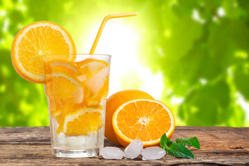 Natural lemonade with mint and fresh oranges on wooden table.