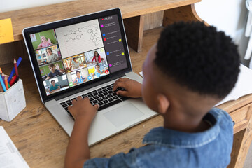 African american boy typing message on laptop during video call while learning in online class