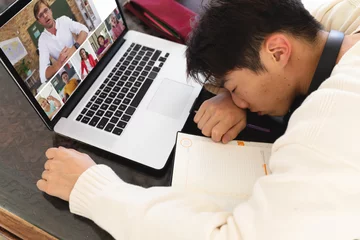 Keuken foto achterwand Aziatische plekken Hoge hoekmening van Aziatische tiener die voor laptop slaapt tijdens online lezing thuis