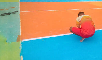 a man painting a volleyball court
