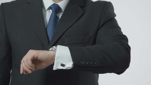 detail of man hands fix watch, office black suit and tie