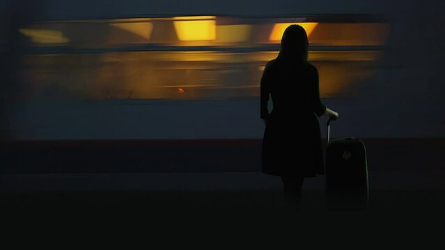 Woman silhouette stand with back in station  platform, train pass fast, new life