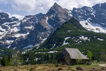 Fototapeta na wymiar Gasienicowa Valley. Tatra Mountains. An old hut in the background of the Koscielec peak.