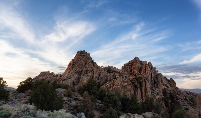 Fototapeta na wymiar Dry rocky desert mountain landscape with trees. Sunny Sunset Sky. California, United States of America. Nature Background.